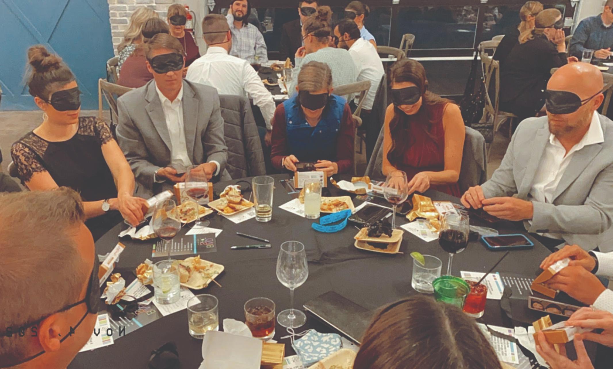 Image of dinner guests engaging in a blindness exercise.